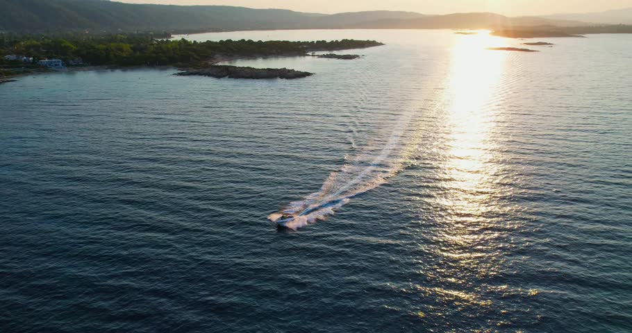 Spectacular sunset over the sea with a boat speeding across the water