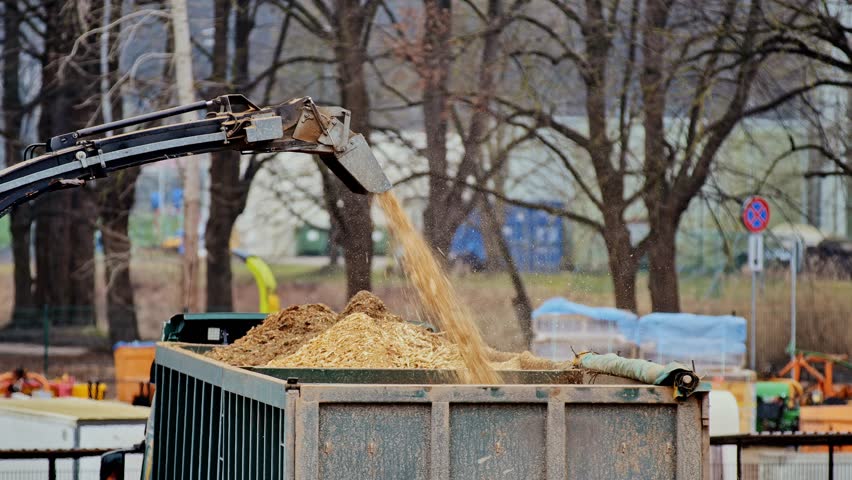 Springtime wood processing – sawdust and timber chips falling into a truck, Riga