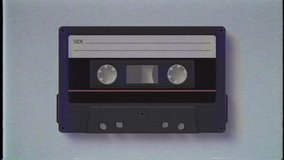Vintage black audio cassette tape spinning in the background with noise and dust - Powered by Shutterstock - Get 15% off with code: PIKWIZARD15