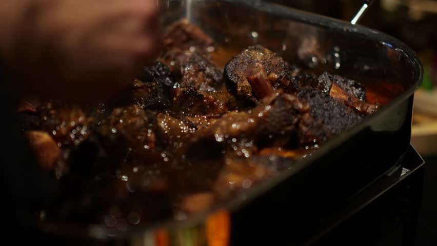 Slow-cooked short ribs with a rich glaze, served in a roasting pan with deep, savory flavors.