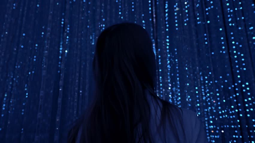 A mesmerizing moment of a woman captivated by the immersive light art installation at TeamLab Planets Tokyo.