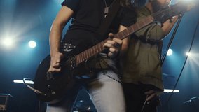 Energetic rock musicians performing on stage, playing electric guitar and singing with intense passion during electrifying live concert - Powered by Shutterstock - Get 15% off with code: PIKWIZARD15