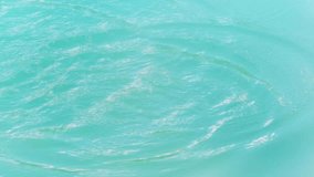close-up of spreading water wave in turquoise smooth water surface, slow motion texture in sunshine - Powered by Shutterstock - Get 15% off with code: PIKWIZARD15