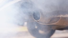 Close up of a car exhaust pipe emitting thick smoke, indicating pollution and vehicle emissions, static - Powered by Shutterstock - Get 15% off with code: PIKWIZARD15