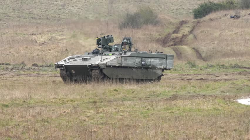 British army General Dynamics Ajax tank; (turreted, reconnaissance and strike) digitised, tracked, armoured fighting vehicle (AFV) in action being tested across muddy ground