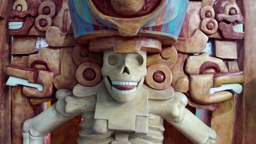 A skeleton is sitting on a chair. The skeleton has a smile on its face. The chair is brown
