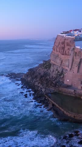 Scenic view of the seaside Azenhas do Mar fishing village on cliff on Atlantic ocean coast, Portugal in evening twilight
