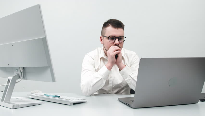 A businessman, young software developer working at a computer in an office. Concept innovative approach to managing online investments and business processes.