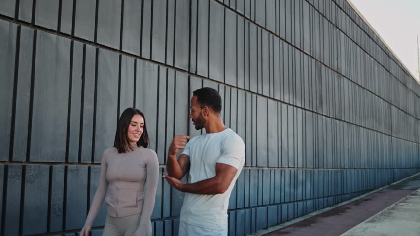 Personal trainer explaining exercises to client outdoors