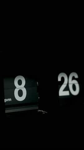 Flipping clock on a black background, in the style of time-lapse video.