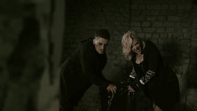 Punk musician duo performs dramatically in an abandoned building. Intense expressions and bold gestures showcase their raw energy. Their edgy outfits add vibrancy to the desolate space. - Powered by Shutterstock - Get 15% off with code: PIKWIZARD15