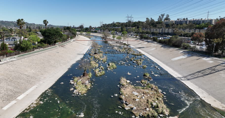Glendale Narrows, LA River, Los Angeles, California, USA, March 19th 2025, Water flows down the Glendale Narrows through rocks and trees surrounded by pavement. 