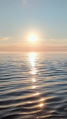 Scenic sunrise over calm sea, gentle waves reflecting sun rays