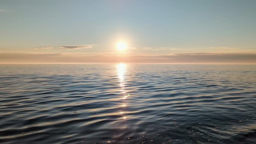 Bright sunrise sun rising above calm sea water, peaceful and beautiful nature scene