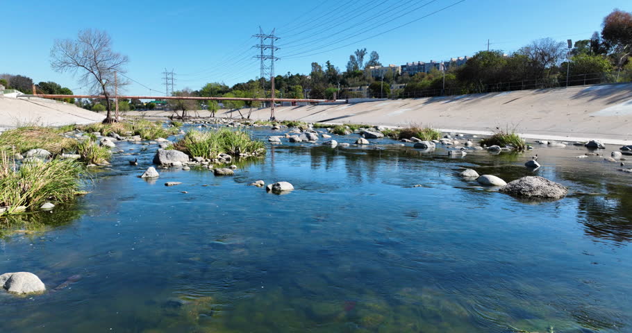 Glendale Narrows, LA River, Los Angeles, California, USA, March 19th 2025, Water flows down the Glendale Narrows through rocks and trees surrounded by pavement. 