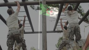 Navigating monkey bars, military personnel in camouflage with Algerian flag visible. training, armed forces, soldier, exercise, obstacle, teamwork - Powered by Shutterstock - Get 15% off with code: PIKWIZARD15