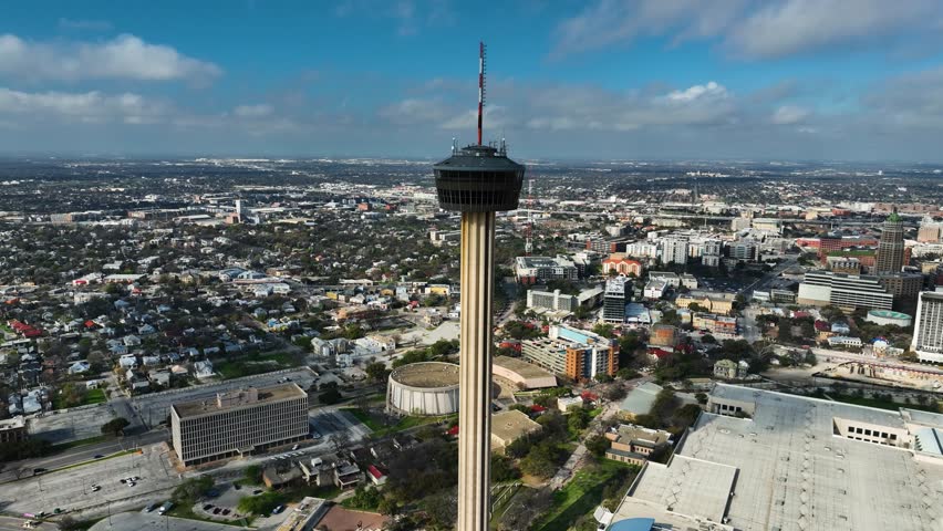 Panoramic drone shot circling the Tower of the Americas, in sunny San Antonio