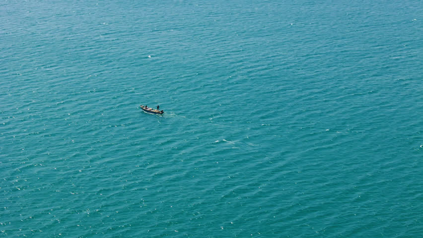 Aerial view of a lone fishing boat in the deep blue ocean