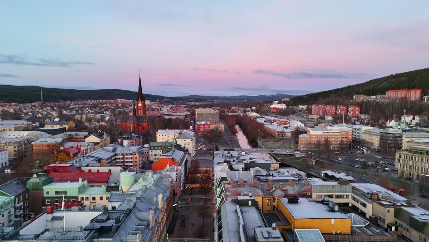 Stunning aerial sunrise view of Sundsvall brick church, river, and pastel sky