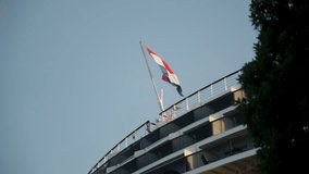 Bottom up view of the Dutch flag on a large cruise ship docked in port. - Powered by Shutterstock - Get 15% off with code: PIKWIZARD15