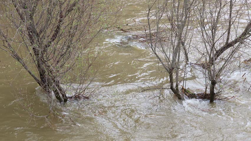 Madrid, Spain; March, 21, 2025: The Manzanares River overflowing. Slow motion footage of strong river currents. Powerful water in movement. Mother Nature in motion. 
