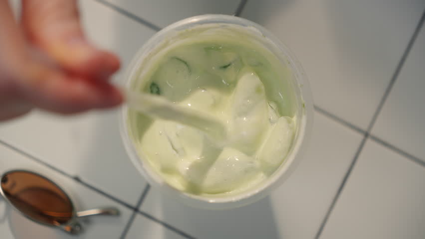 Top down tabletop view of iced tea or coffee with matcha, which a girl