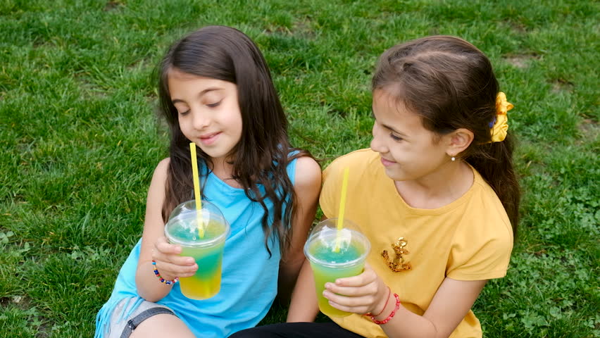 Children drinking cocktail on grass. Selective focus.