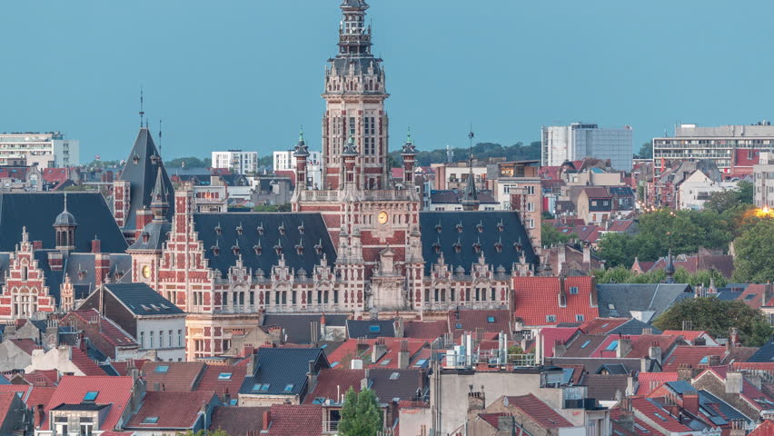 Aerial view of Schaerbeek Town Hall day to night transition timelapse in Brussels, Belgium. Neo-Renaissance architecture surrounded by illuminated red-roofed houses. Cityscape and historical charm