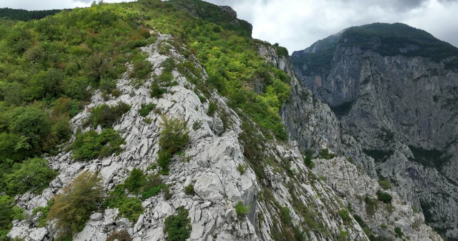 Vertical Canyons Surrounding Lake Koman On Drin River In Kukes, Shkoder, Albania. panning drone, tilt-down reveal