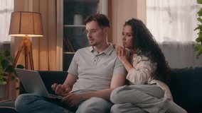 Caucasian couple family man male husband boyfriend love with Hispanic woman female girl girlfriend wife at home couch sofa using laptop together choose booking online internet shopping order delivery - Powered by Shutterstock - Get 15% off with code: PIKWIZARD15