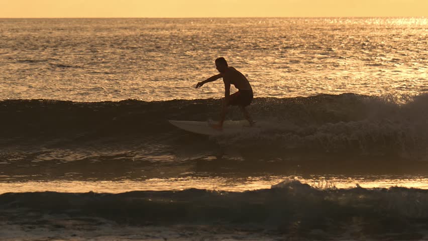 The man is surfing and doing tricks. Beautiful sunset on the coast of the Indian Ocean. High quality 4k footage