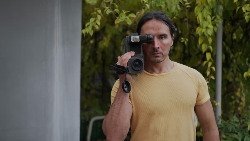 A skilled and candid filmmaker captures the beauty of nature outdoors using a vintage camera