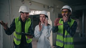 Three Caucasian workers construction builders problem chaos accident developer inspector team woman talk mobile phone men arguing talking walkie talkie trouble difficulty engineers discuss build plan - Powered by Shutterstock - Get 15% off with code: PIKWIZARD15