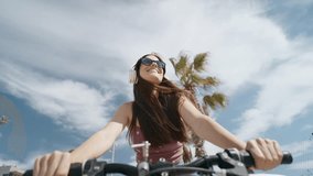 Video of pretty young woman listening music with headphone while enjoying with bike strolling along the seafront - Powered by Shutterstock - Get 15% off with code: PIKWIZARD15