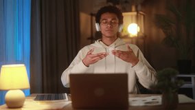 African American man with headphones meditates in front of laptop before starting work in home sits calmly with closed eyes and relaxed promoting mindfulness focus and work-life balance at night - Powered by Shutterstock - Get 15% off with code: PIKWIZARD15