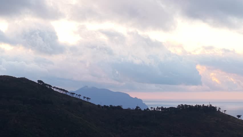 Big clouds running fast above a coastal city in Italy, aerial shot of landscape