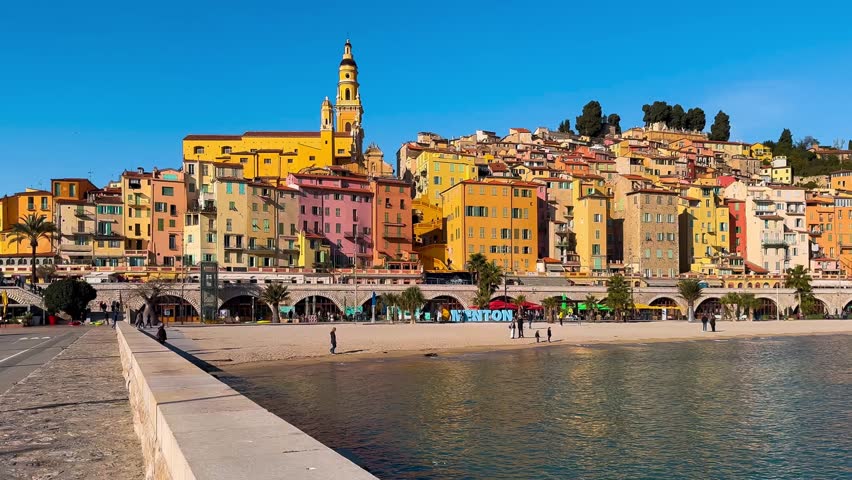 Colourful houses, palm trees on the embankment in Menton, Provence, Alps, Cote d'Azur France. High quality 4k footage