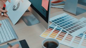 A person types on a laptop surrounded by vibrant color palettes and design sketches, capturing the essence of creative work in a modern workspace. SACTR - Powered by Shutterstock - Get 15% off with code: PIKWIZARD15