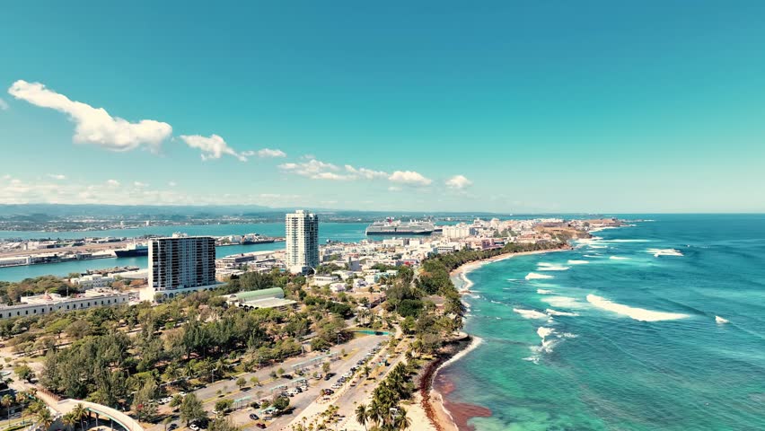 4K drone video of El Morro and Old San Juan in Puerto Rico. Aerial view of the historic Spanish fortress, colorful colonial buildings, and ocean coast on a bright sunny day.