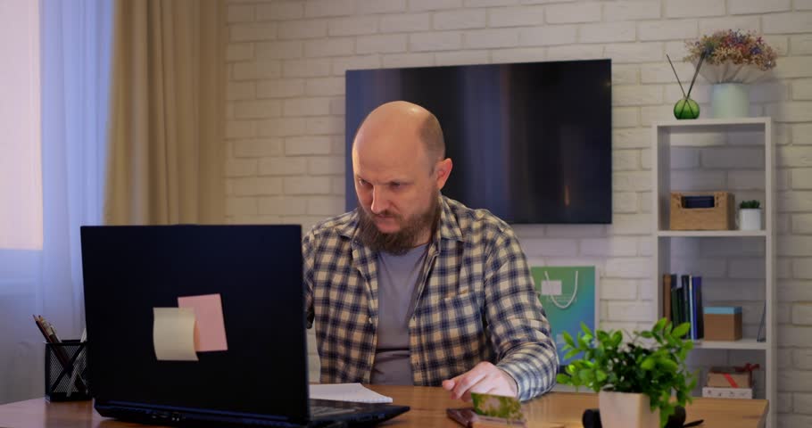 Knowledgeable man managing home-based business, knowledge reflected in strategic planning, knowledge enhancing decision-making, knowledge essential for business success, perfect for corporate videos