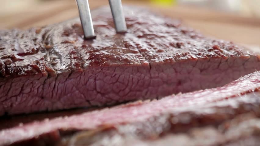 A skilled chef cuts the steak into thin slices, preserving the tenderness and flavor of the freshly cooked beef, resulting in a tender and delicious