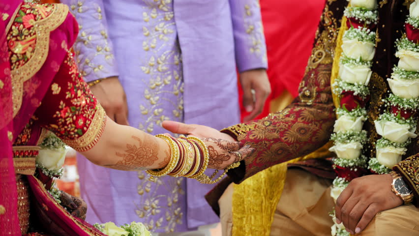 The Indian Hindu Rituals that performed during the holy wedding ceremony. Bride and groom holding each others hands. Close up shot of part of wedding ceremony