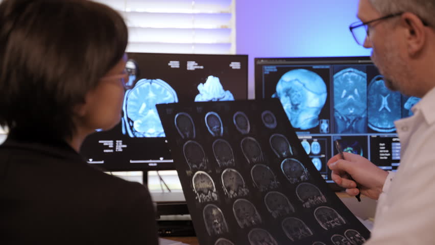 A patient MRI scan is reviewed by doctors and the patient to assess brain health and determine the best treatment.
