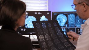 A patient MRI scan is reviewed by doctors and the patient to assess brain health and determine the best treatment. - Powered by Shutterstock - Get 15% off with code: PIKWIZARD15
