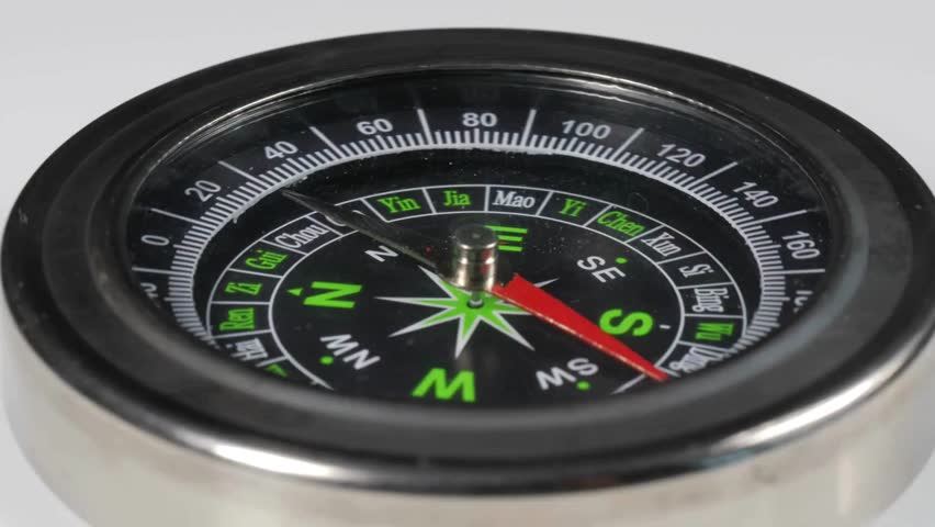 detail shot of a compass. Closeup on a compass pointing direction. geography, navigation, travel, tourism and exploration concept. Simple navigation tools to orient in the world.