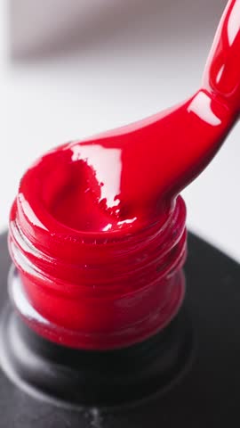 red nail polish bottle on white  background and a brush showing perfect smooth texture, cosmetic product closeup macro, top view