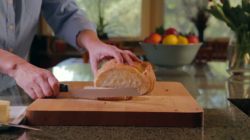 Woman slicing and buttering bread