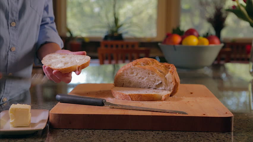 Woman slicing and buttering bread