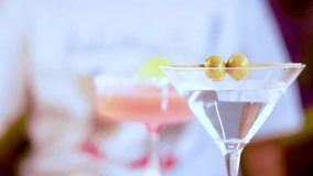 Vibrant cocktails in various glasses with olives and lime garnishes, set against a blurred background, showcasing a lively atmosphere - Powered by Shutterstock - Get 15% off with code: PIKWIZARD15