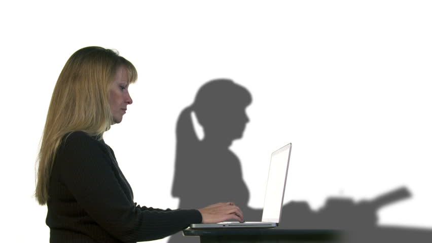 Modern woman types on a laptop with a shadow of the past, her own shadow, using